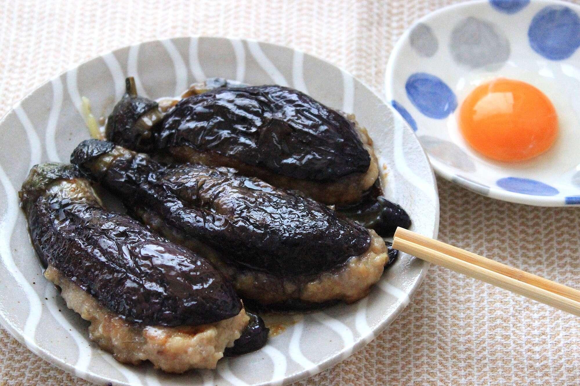 卵黄を絡めて二度おいしい！ 甘辛味と鶏肉のうまみがしっかり染みた「なすの月見つくね」